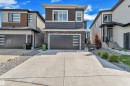 Contemporary exterior featuring a concrete driveway, attached two-car garage with frosted pane windows, and stone veneer accents - 1809 18A Avenue, Edmonton, AB  - Outdoor With Facade 
