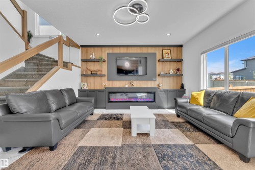 Living area featuring a floor-to-ceiling accent wall with a built-in electric fireplace and shelving - 1809 18A Avenue, Edmonton, AB - Indoor Photo Showing Living Room With Fireplace
