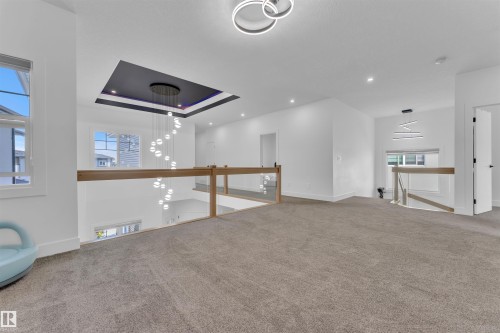 Upper level featuring contemporary lighting fixtures, light wood-finish and glass railings, recessed lighting, and carpeted flooring - 1809 18A Avenue, Edmonton, AB - Indoor Photo Showing Other Room
