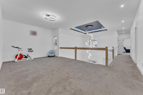 Versatile loft area with plush gray carpeting and a contemporary flush-mount ceiling fixture - 1809 18A Avenue, Edmonton, AB - Indoor