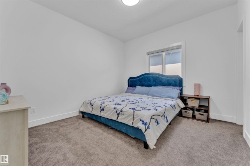 Neutral-toned carpet flooring in a room featuring white walls and a white-trimmed window - 1809 18A Avenue, Edmonton, AB - Indoor Photo Showing Bedroom