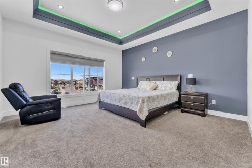 Tray ceiling with recessed lighting and accent lighting, large window with roller shade, and plush carpeting - 1809 18A Avenue, Edmonton, AB - Indoor Photo Showing Bedroom