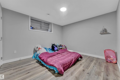 Neutral gray walls complement the wood-finish flooring in this room - 1809 18A Avenue, Edmonton, AB - Indoor Photo Showing Bedroom