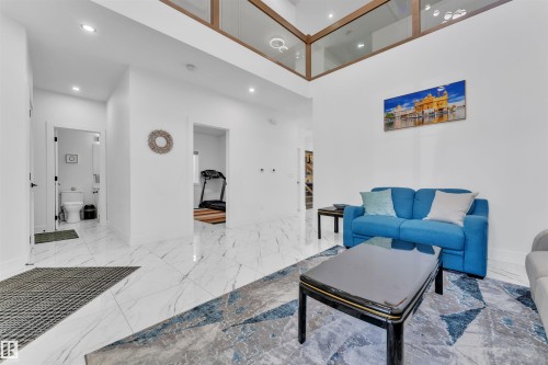 Living area featuring high ceilings, recessed lighting, and large format marble-look tile flooring - 1809 18A Avenue, Edmonton, AB - Indoor