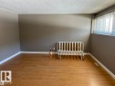Room featuring wood-finish flooring, neutral wall paint, white baseboards, and a window with horizontal blinds - 2 6920 101 Avenue Nw, Edmonton, AB  - Indoor Photo Showing Other Room 