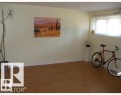 Spacious interior room featuring wood-finish flooring and light-toned walls - 2 6920 101 Avenue Nw, Edmonton, AB  - Indoor Photo Showing Other Room 