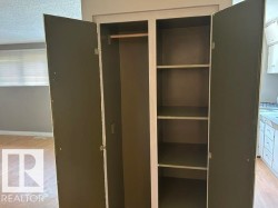 Built-in cabinet featuring bi-fold doors, a clothing rod, and multiple shelves - 