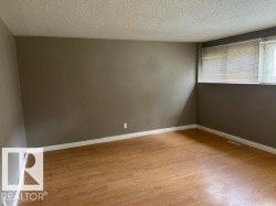 Room featuring wood-finish flooring, neutral wall tones, and white baseboards - 
