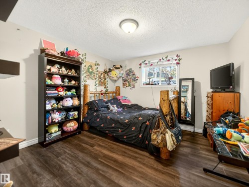 Spacious room featuring wood-finish flooring, light-toned walls, and a window for natural illumination - 7 Oakbay Point(E), St. Albert, AB - Indoor