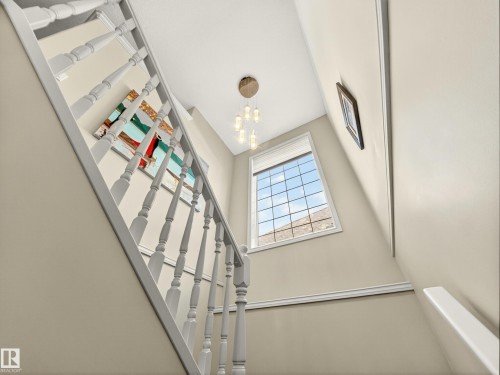Staircase featuring painted wood balusters and a white handrail, complemented by neutral wall paint - 7 Oakbay Point(E), St. Albert, AB - Indoor Photo Showing Other Room