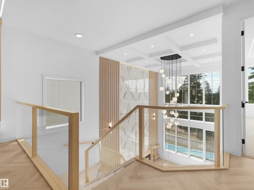 Two-story foyer featuring a striking chandelier, coffered ceiling, hardwood flooring, and glass panel railings with light wood newel posts - 2070 Collip Crescent, Edmonton, AB - Indoor Photo Showing Other Room
