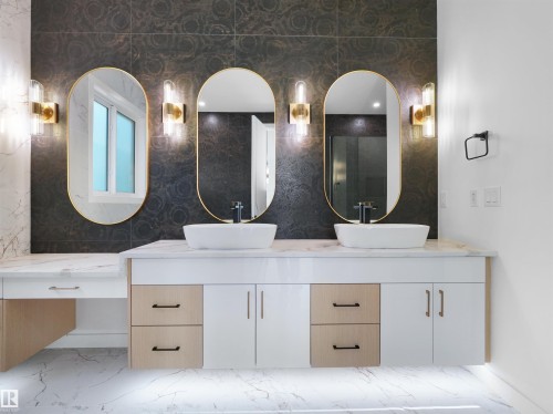 Dual vessel sinks set atop a floating vanity with a marble-finish countertop - 2070 Collip Crescent, Edmonton, AB - Indoor Photo Showing Bathroom