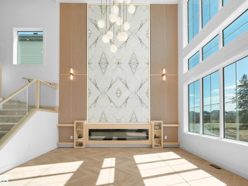 Two-story living area featuring a prominent fireplace wall with a built-in electric fireplace and decorative stone-like paneling - 2070 Collip Crescent, Edmonton, AB - Indoor Photo Showing Other Room