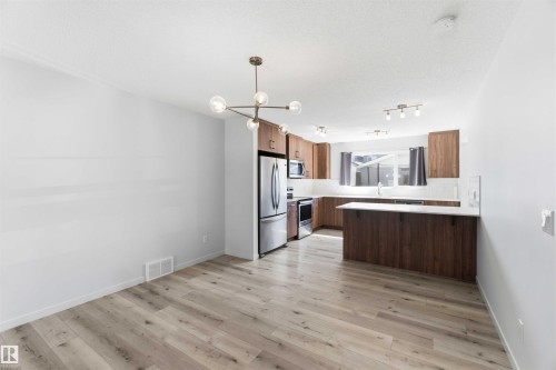 Open-concept kitchen and dining area with wood-finish flooring - 22371 93 Avenue, Edmonton, AB - Indoor Photo Showing Kitchen