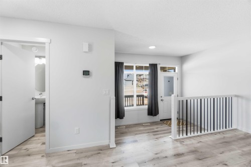 Entryway featuring wood-finish flooring, white walls, and a white front door with a transom window - 22371 93 Avenue, Edmonton, AB - Indoor Photo Showing Other Room