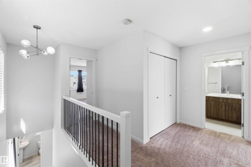 Upper level landing with plush carpeting, modern chandelier, and recessed lighting - 22371 93 Avenue, Edmonton, AB - Indoor Photo Showing Other Room
