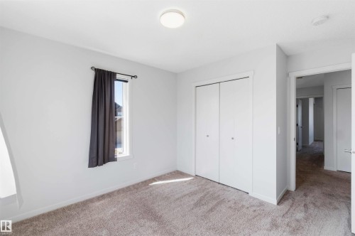 Neutral wall paint with carpeted flooring, a flush mount ceiling light, and white bi-fold closet doors - 22371 93 Avenue, Edmonton, AB - Indoor