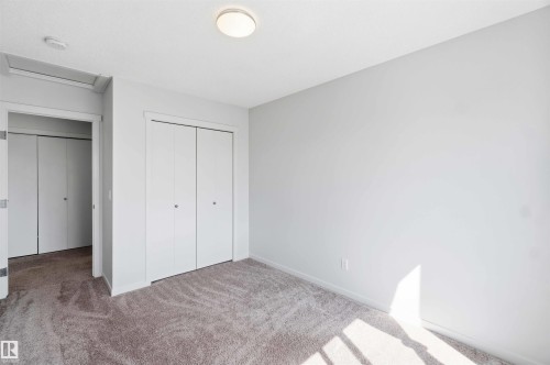 Bedroom featuring neutral-toned carpet, light gray wall paint, a flush-mount ceiling light, and white bi-fold closet doors - 22371 93 Avenue, Edmonton, AB - Indoor