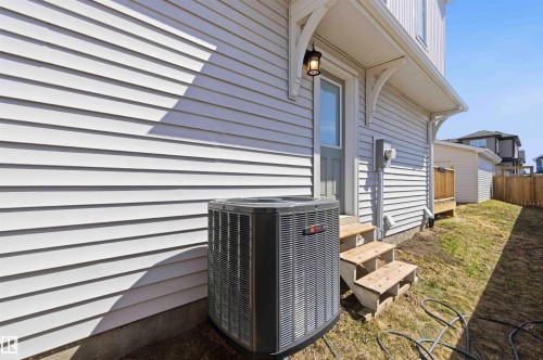 Rear exterior featuring white horizontal siding, a utility door with an overhead awning, and a three-step wooden staircase - 22371 93 Avenue, Edmonton, AB - Outdoor With Exterior
