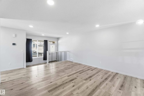 Spacious interior with wide plank wood-finish flooring, recessed lighting, and a neutral color palette - 22371 93 Avenue, Edmonton, AB - Indoor Photo Showing Other Room