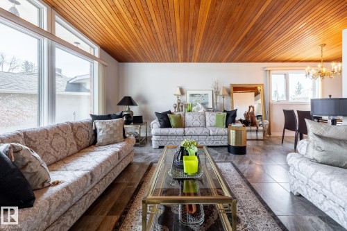 Vaulted wood-paneled ceiling with an accent wall of large windows - 16536 103 Street, Edmonton, AB - Indoor Photo Showing Living Room
