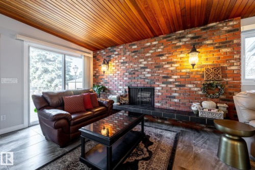 Brick-faced fireplace with a dark-tiled hearth and integrated firebox - 16536 103 Street, Edmonton, AB - Indoor Photo Showing Living Room With Fireplace