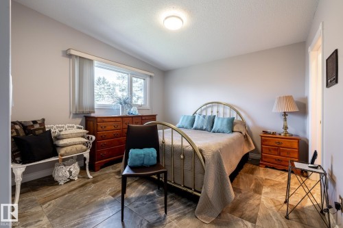 Spacious room featuring broad windows with horizontal blinds, light gray walls, and large format natural stone flooring - 16536 103 Street, Edmonton, AB - Indoor Photo Showing Bedroom
