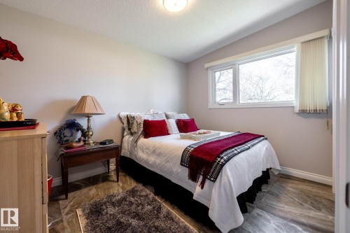 Bedroom featuring a single window with white trim, light gray walls, and wood-finish flooring - 16536 103 Street, Edmonton, AB - Indoor Photo Showing Bedroom