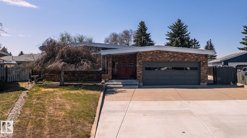 Brick exterior featuring a flat roofline and integrated garage - 16536 103 Street, Edmonton, AB - Outdoor