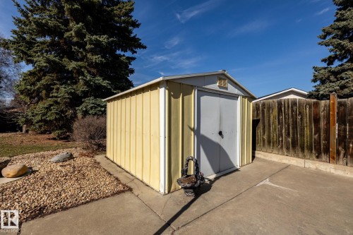 Metal storage shed with a light yellow corrugated exterior and a light gray door - 16536 103 Street, Edmonton, AB - Outdoor With Exterior