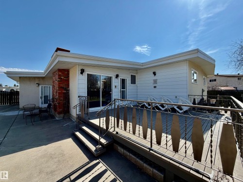 Expansive outdoor deck with an ornate metal railing, featuring a sliding glass door entry to the interior - 16536 103 Street, Edmonton, AB - Outdoor With Exterior