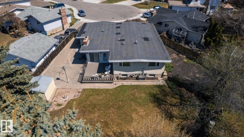 Rear exterior featuring a flat roofline, an elevated wood deck, and a concrete patio - 16536 103 Street, Edmonton, AB - Outdoor With View