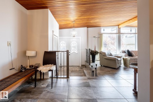 Entryway featuring large format tile flooring, a wood-paneled vaulted ceiling, and an ornate front door with decorative glass inserts - 16536 103 Street, Edmonton, AB - Indoor