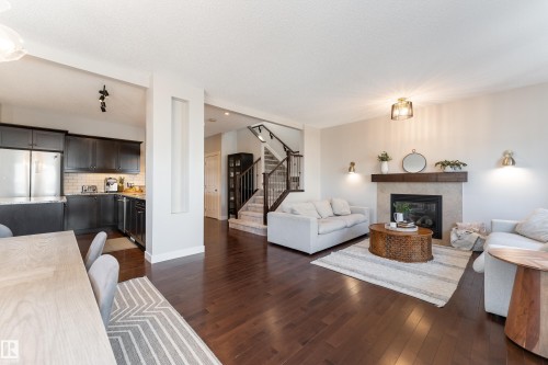 Open-concept living space featuring rich wood-finish flooring - 22064 95 Avenue, Edmonton, AB - Indoor Photo Showing Living Room With Fireplace