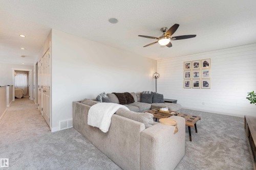 Carpeted living area featuring a ceiling fan with light, white shiplap accent wall, and recessed lighting - 22064 95 Avenue, Edmonton, AB - Indoor