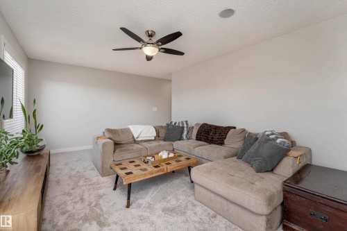 Carpeted living space featuring a ceiling fan with integrated lighting, recessed ceiling speaker, and a window with horizontal blinds - 22064 95 Avenue, Edmonton, AB - Indoor Photo Showing Living Room