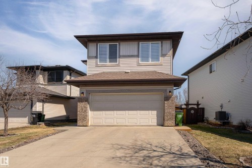 Two-story residence featuring light-colored siding and a two-car attached garage with a paved driveway - 22064 95 Avenue, Edmonton, AB - Outdoor With Exterior