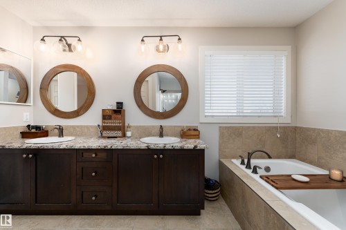 Double vanity with dark wood cabinetry, granite-style countertop, and dual vessel sinks - 22064 95 Avenue, Edmonton, AB - Indoor Photo Showing Bathroom