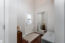 Entryway featuring a white paneled door with decorative glass inserts, dark wood-finish flooring, and light neutral wall paint - 22064 95 Avenue, Edmonton, AB  - Indoor Photo Showing Other Room 