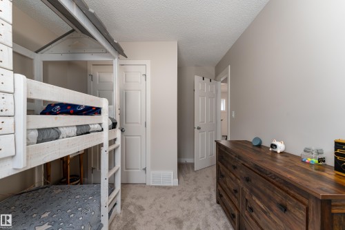 Carpeted room featuring light gray walls, white trim, and a classic paneled interior door with a brushed nickel knob - 22064 95 Avenue, Edmonton, AB - Indoor Photo Showing Bedroom