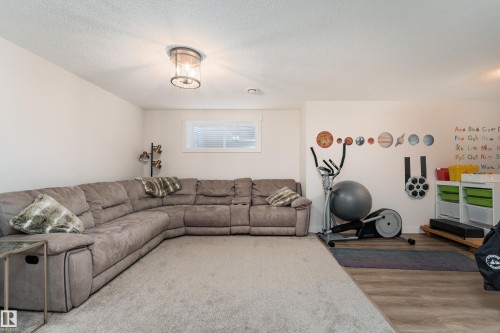 Flexible room featuring neutral wall tones, recessed lighting, a window with blinds, and a combination of carpeted and wood-finish flooring - 22064 95 Avenue, Edmonton, AB - Indoor Photo Showing Living Room