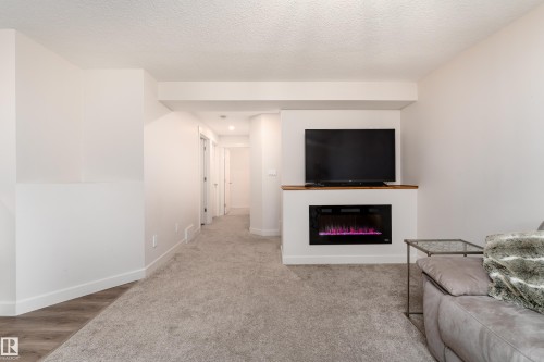 Built-in media console with wood-finish mantel and electric fireplace - 22064 95 Avenue, Edmonton, AB - Indoor With Fireplace