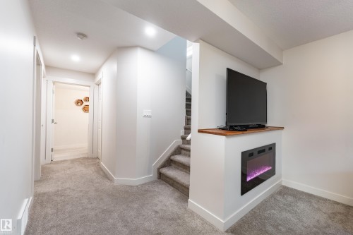 Integrated electric fireplace with wood-finish mantel and recessed lighting - 22064 95 Avenue, Edmonton, AB - Indoor Photo Showing Other Room