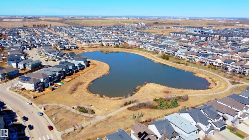 Serene neighborhood with a central pond feature, bordered by a walking path - 22064 95 Avenue, Edmonton, AB - Outdoor With Body Of Water With View