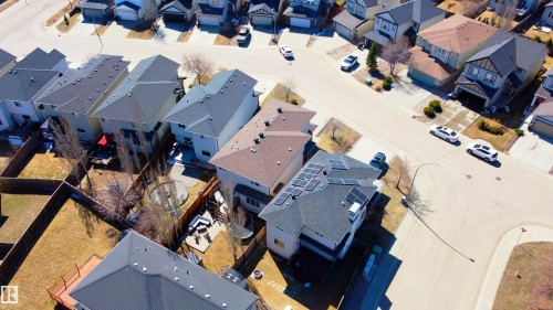 Modern suburban property featuring a multi-gable roof with integrated solar panels, a fenced backyard, and an attached garage - 22064 95 Avenue, Edmonton, AB - Outdoor With View