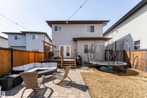Rear exterior featuring light grey siding, a wood deck with railing, and double glass panel doors - 22064 95 Avenue, Edmonton, AB - Outdoor With Deck Patio Veranda With Exterior