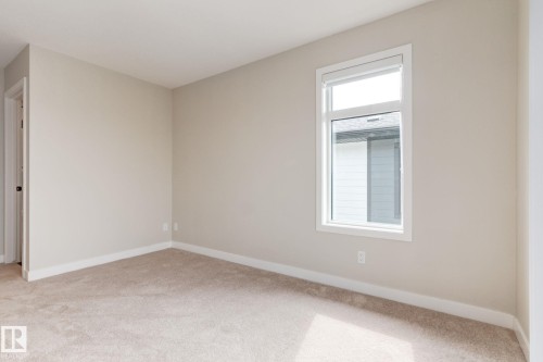 Neutral-toned walls and plush carpet flooring complement a white trim package - 44 16231 19 Avenue, Edmonton, AB - Indoor Photo Showing Other Room