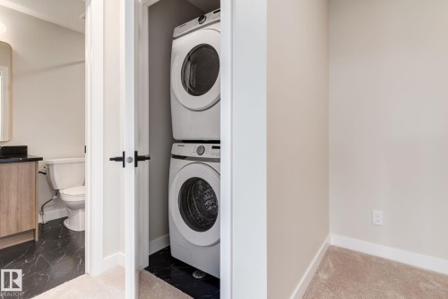 Dedicated laundry closet featuring a stackable washer and dryer unit - 44 16231 19 Avenue, Edmonton, AB - Indoor Photo Showing Laundry Room