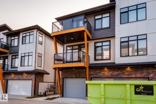 Modern multi-story townhouse facade featuring mixed material siding, brick accents, and black-framed windows - 44 16231 19 Avenue, Edmonton, AB - Outdoor With Balcony