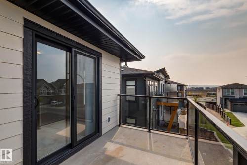 Private outdoor balcony featuring concrete flooring and black-framed glass railings - 44 16231 19 Avenue, Edmonton, AB - Outdoor With Balcony With Exterior